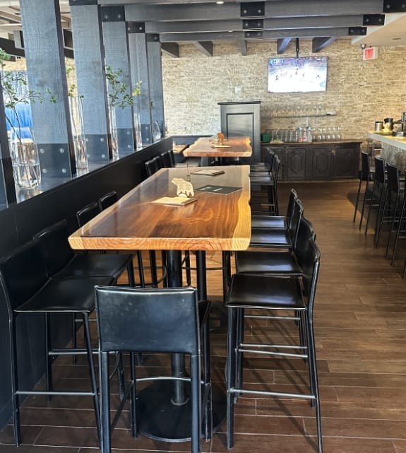 High-top long timber table setups for corporate mixers or birthday gatherings inside a restaurant in Banff, Alberta.